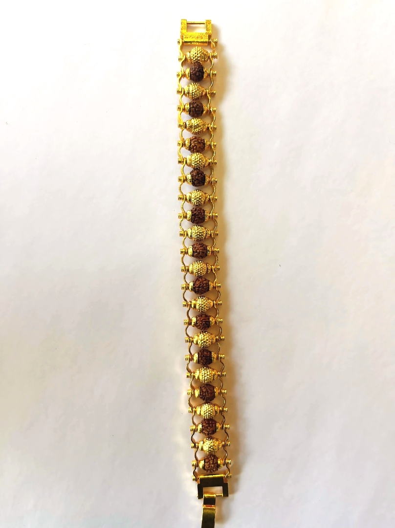 Hand wearing Fancy Bronze Rudraksham Bracelet with original Rudraksha beads and bronze ball design, premium spiritual wristwear for men