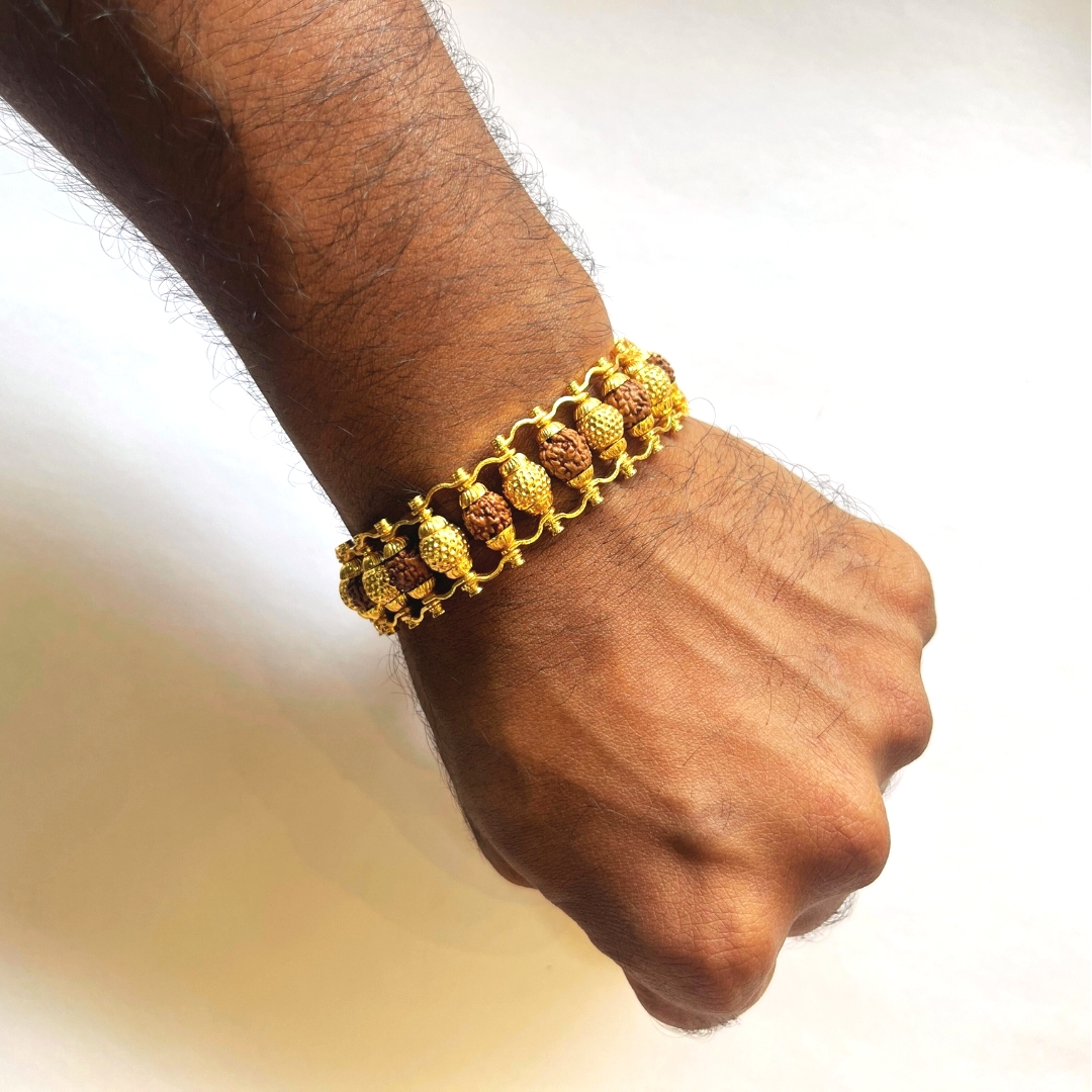 Hand wearing Fancy Bronze Rudraksham Bracelet with original Rudraksha beads and bronze ball design, premium spiritual wristwear for men.